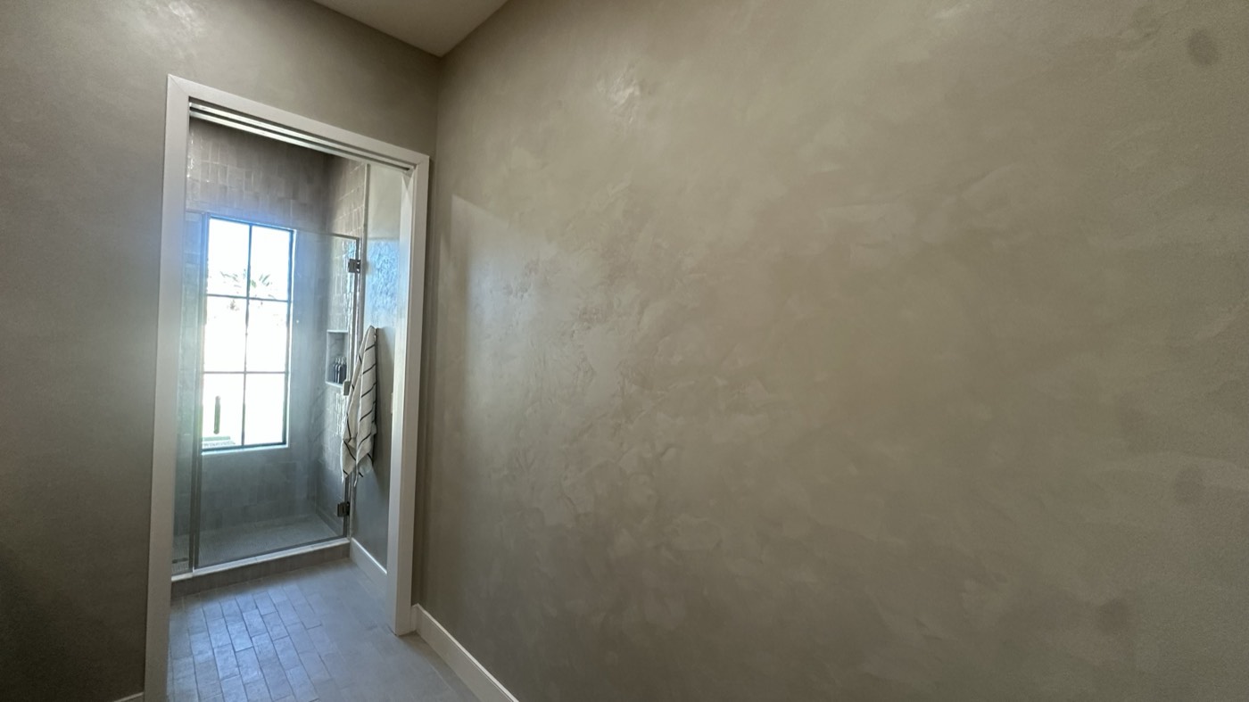 Broad mottled tadelakt bathroom wall opening onto a tiled walk-in shower, Phoenix
